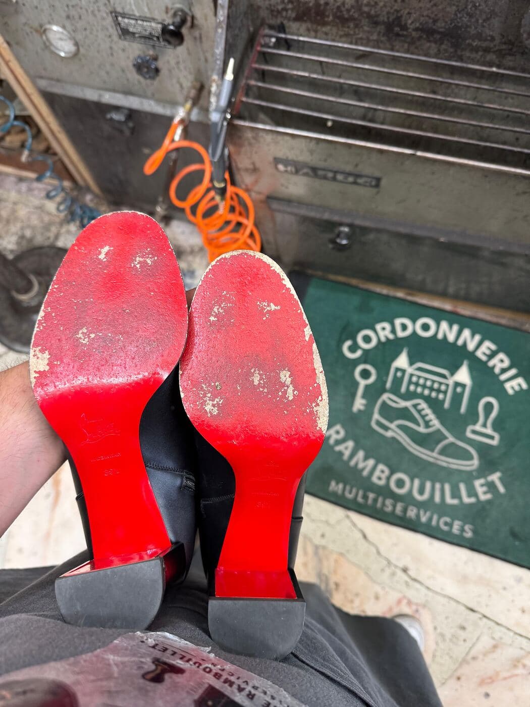 Semelle rouge usée avant intervention à la cordonnerie